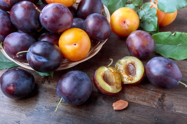 Rijpe sappige pruimen op een houten tafel. — Stockfoto