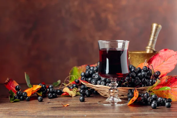 Fresh juice of ripe black chokeberry in glass and berries with l — Stock Photo, Image