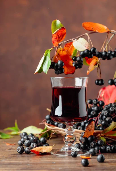 Fresh juice of  black chokeberry in glass and berries with leave — Stock Photo, Image