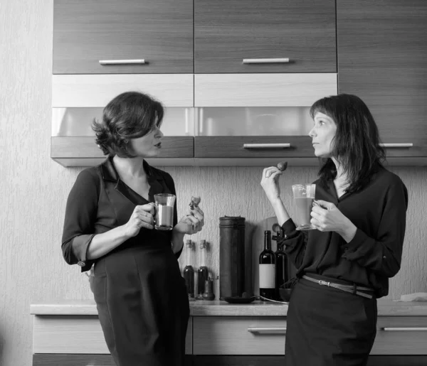 두 여자 친구 얘기 하 고 부엌에서 커피를 마시는. — 스톡 사진
