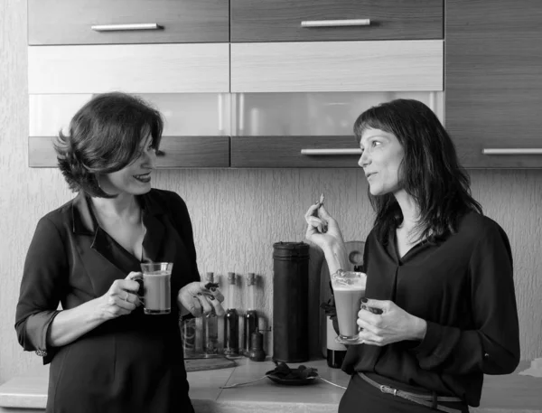 Dwie dziewczyny porozmawiać i napić się kawy w kuchni. — Zdjęcie stockowe