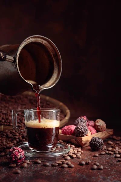 Black coffee is poured into a small glass cup. — Stock Photo, Image