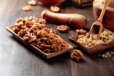 Eski ahşap bir masa üzerinde ahşap bir çanak ceviz. 