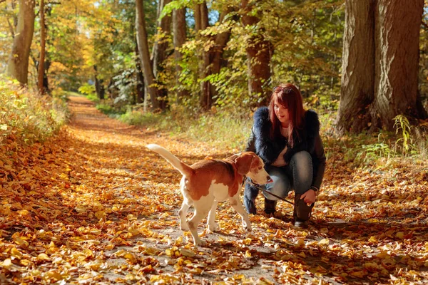 Junge Frau geht mit Hund im Herbstpark spazieren. — Stockfoto