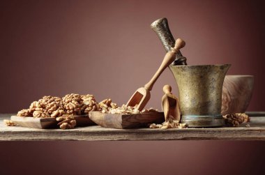 Ezilmiş ve eski bir ahşap tabl üzerinde ahşap bir çanak bütün ceviz