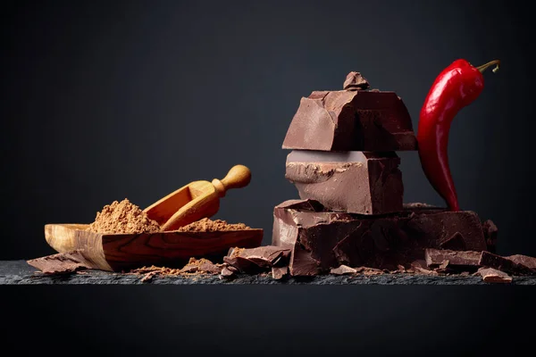 Cioccolato nero con pepe rosso e piatto di legno con cacao in polvere — Foto Stock