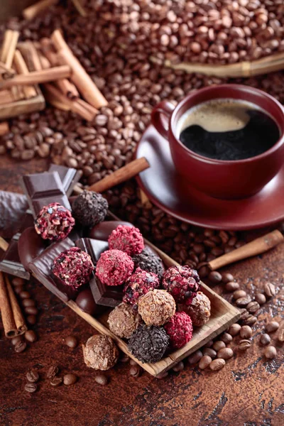 Vários chocolates e xícara de café preto . — Fotografia de Stock