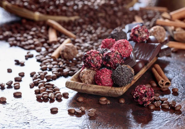 Various chocolates in wooden dish on a brown table. — Stock Photo, Image