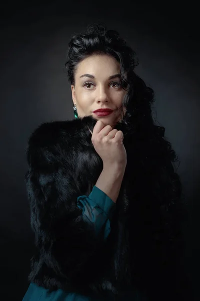 Jeune belle femme avec de longs cheveux bouclés en manteau de fourrure noire . — Photo