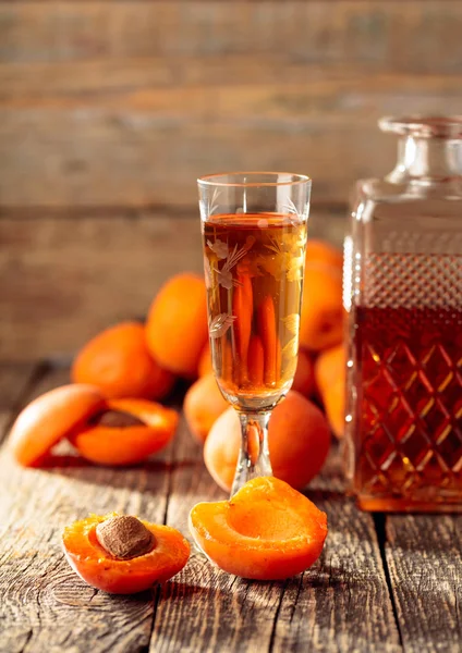 Apricot liquor and fresh apricots on a old wooden table. — Stock Photo, Image