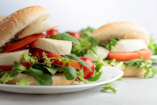 Sandwich con mozzarella, tomate y ensalada en la mesa de la cocina . —  Fotos de Stock