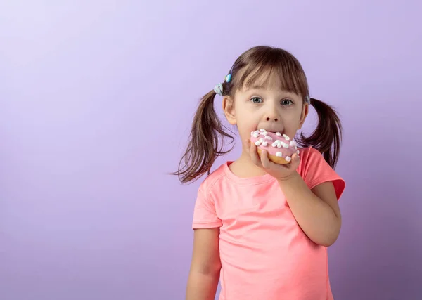 Four-year-old girl eat donut. — Stock Photo, Image