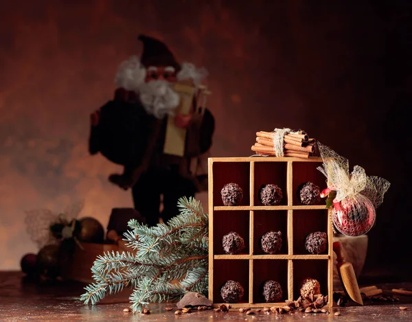 Chocolate candy in wooden box and Christmas decorations on a old — Stock Photo, Image