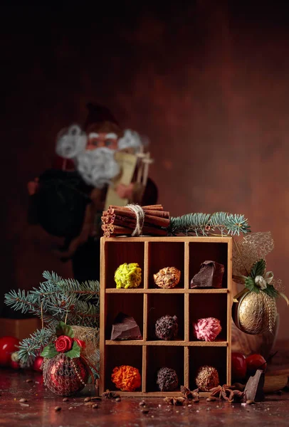 Chocolade snoep in houten kist en kerstversiering op een oude — Stockfoto