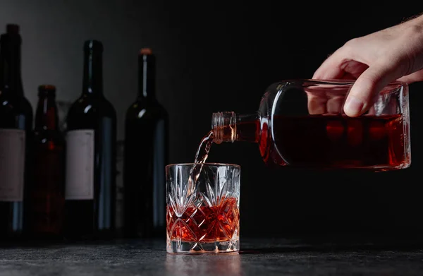 Barman schenkt whisky in een glas aan de bar. — Stockfoto