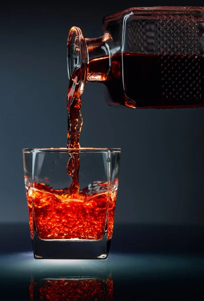 デカンタからグラスに注ぐアルコール飲料. — ストック写真