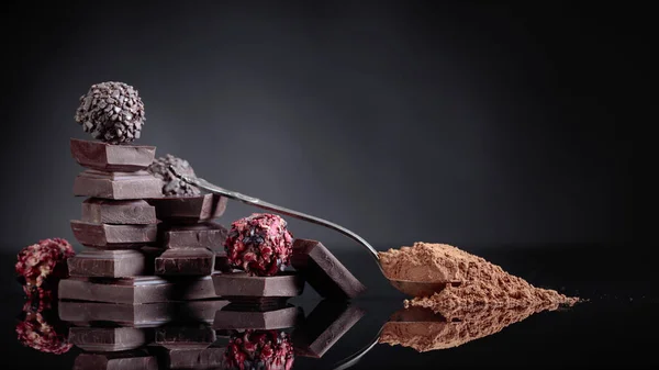 Doces de chocolate, pedaços de chocolate quebrados e colher com cacau — Fotografia de Stock