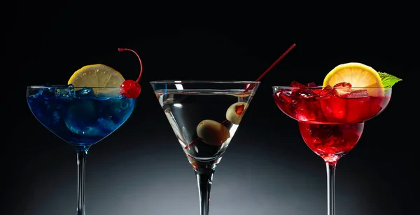 Two colorful cocktails and dry martini with green olives. — Stock Photo, Image