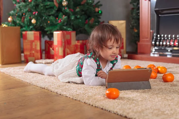 Маленькая девочка с табличкой в комнате с рождественскими украшениями — стоковое фото