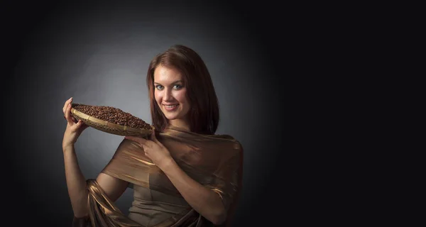 Приваблива жінка зі смаженими кавовими зернами в кошику на темному б — стокове фото