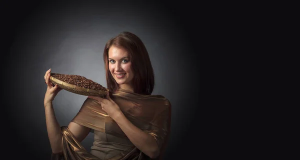 Belle femme avec des grains de café torréfiés dans le panier sur un b foncé — Photo