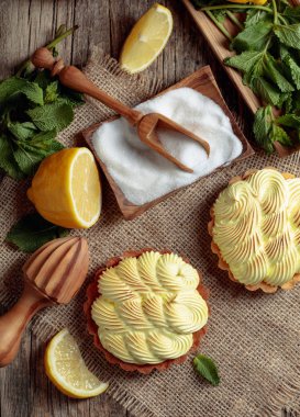 Eski ahşap bir masada limon kremalı ve nane şekerli tart. 
