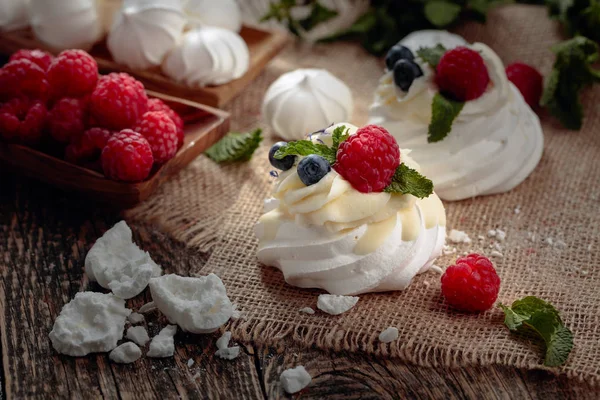 Dessert Pavlova with raspberries, blueberries and mint on a old — Stock Photo, Image