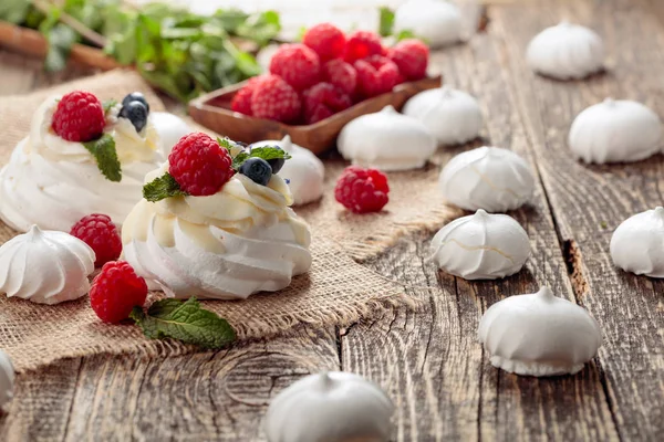 Dessert pavlova mit Himbeeren, Blaubeeren und Minze auf einem alten — Stockfoto