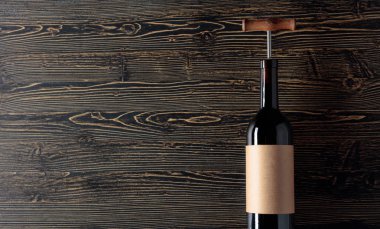 Tirbuşonlu kırmızı şarap şişesi. Bir şişe boş eski kağıt üzerinde l