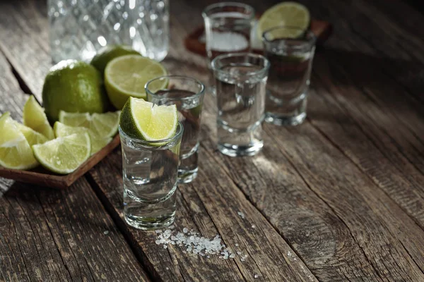 Tequila avec sel et citron vert sur un vieux fond en bois . — Photo