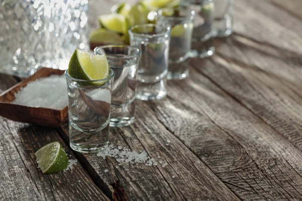 Tequila se solí a vápnem na starém dřevěném pozadí. — Stock fotografie