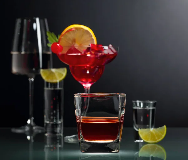 Várias bebidas alcoólicas em um fundo preto . — Fotografia de Stock