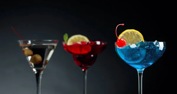 Colorful cocktails and dry martini with green olives. — Stock Photo, Image