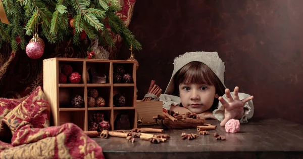 Маленькая девочка в винтажном льняном платье рядом со столом со сладостями — стоковое фото