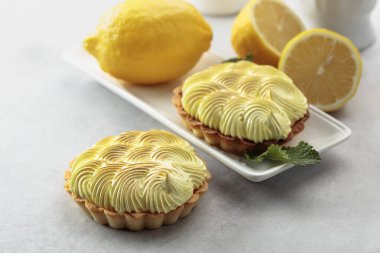 Beyaz bir masada limon kremave nane ile Tartlets. 