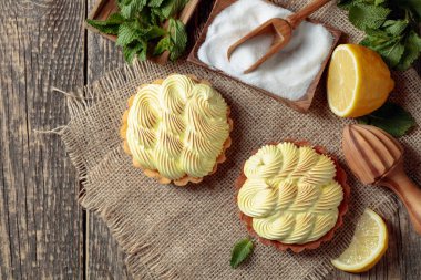 Eski ahşap bir masada limon kremalı ve nane şekerli tart. 