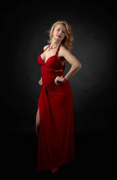 Attraktive Frau mittleren Alters im roten Abendkleid. — Stockfoto