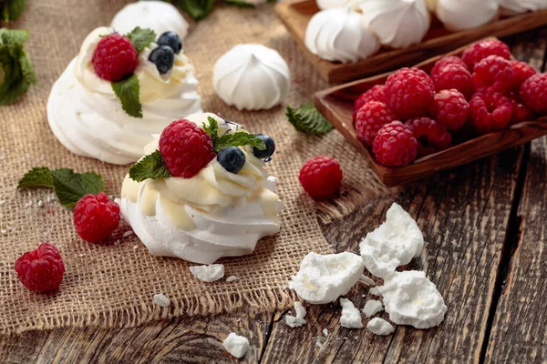 Dessert pavlova mit Himbeeren, Blaubeeren und Minze auf einem alten — Stockfoto