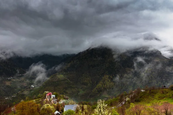 Caucasus village and mountains on dark moody day with big clouds — Stock Photo, Image