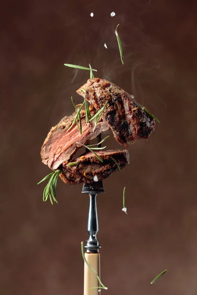 Grilovaný hovězí steak s rozmarýnem na hnědém pozadí. — Stock fotografie