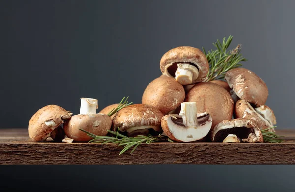 Cogumelos castanhos frescos champignon em uma velha mesa de madeira . — Fotografia de Stock