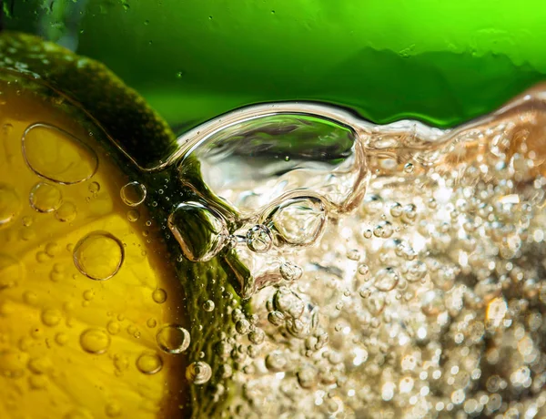 Carbonated drink or cocktail with lime, abstract splashing.