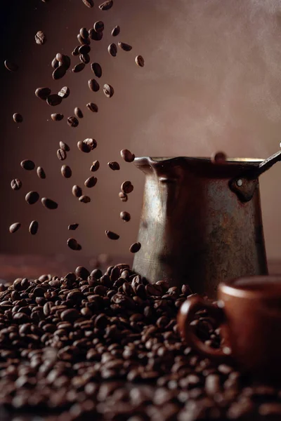 Fallende Kaffeebohnen und alte Kupferkaffeemaschine. — Stockfoto