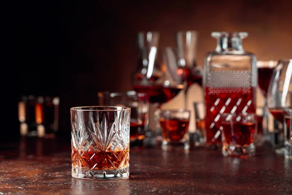 Набор крепких алкогольных напитков в стаканах на коричневой заднице — стоковое фото