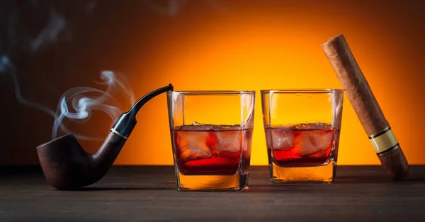 Whiskey with natural ice, cigar and smoking pipe with a smoke. — Stock Photo, Image