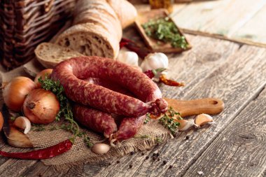 Eski ahşap bir masada ekmek ve baharat ile kuru-tedavi sosis.