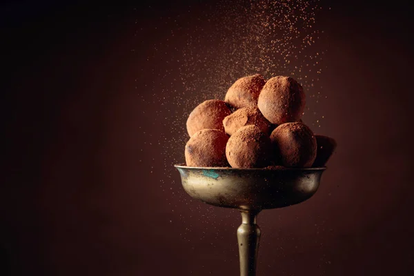 Trufas de chocolate en jarrón de latón viejo espolvoreadas con cacao en polvo — Foto de Stock