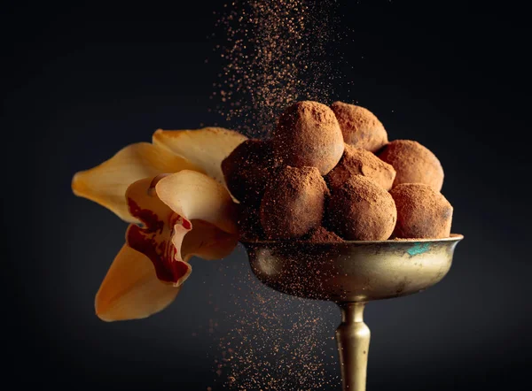 Шоколадные трюфели в старой медной вазе, посыпанной какао-порошком — стоковое фото