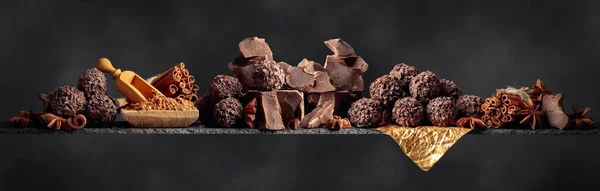 Cioccolato con ingredienti e spezie su sfondo scuro . — Foto Stock