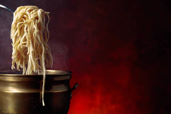 Zelfgemaakte eiernoedels en oude koperen pan met warm water. — Stockfoto